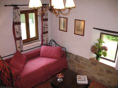 a living room with a red couch and two lamps hanging from the ceiling above it