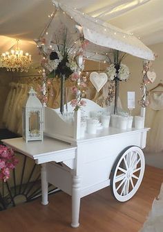 a white cart with flowers and candles on the top is shown in an instagramtion