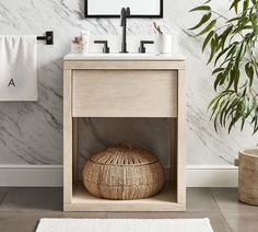 a bathroom with marble walls and flooring next to a bamboo basket on the ground