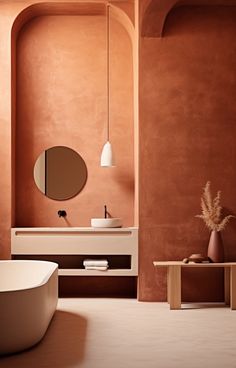 a bath tub sitting next to a white sink in a bathroom under a round mirror