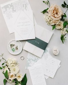 the wedding stationery is laid out with flowers