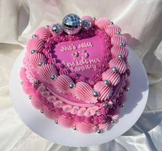 a heart shaped cake with pink frosting and decorations