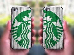 a person holding up two cell phones with the starbucks logo painted on them in front of their faces