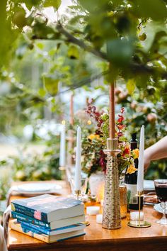 a wooden table topped with books and candles