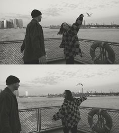 two people are standing on a boat looking at the water and one is flying a kite