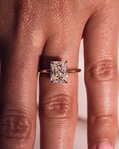 a woman's hand with a ring on it and a diamond in the middle