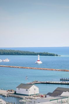 an aerial view of a harbor with boats in the water and a light house near by