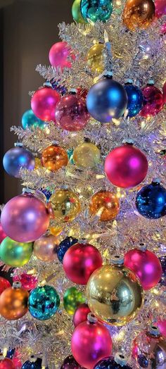 a brightly colored christmas tree is decorated with ornaments