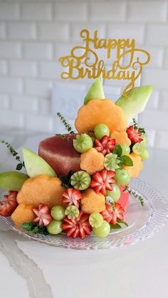 a birthday cake decorated with fruits and flowers