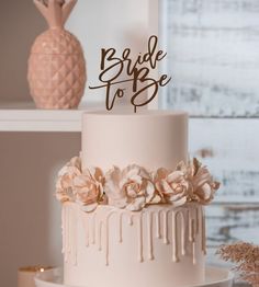 a three tiered cake with white frosting and flowers