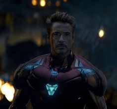 iron man standing in the dark with his hands on his hips