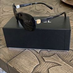 Black Frame, Chanel Logo On Each Side, Elegant Sunnies In Excellent Condition. Right Lens Has Very Faint Vertical And Small Horizontal Scratch. Left Lens Has Very Faint Horizontal Scratches. These Do Not Obscure Vision At All And Are Not Visible When Wearing The Sunglasses. Slight Wear At Bridge Of Nose. Includes Hard Case In Perfect Condition, Unopened Chanel Cleaning Clothes And Dust Bag As Well As Original Box. Elegant Office Sunglasses, Elegant Formal Sunglasses With Polarized Lenses, Chanel Logo, Chanel Sunglasses, Chanel Accessories, Chanel Black, Colored Sunglasses, Oakley Sunglasses, Hard Case