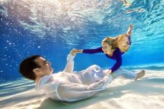 a man and woman are underwater in the water