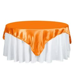 an orange and white table cloth on top of a round table