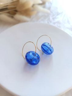 "Add a touch of elegance to your everyday look with these Contemporary Handmade Earrings. Crafted with precision, these exquisite earrings showcase stunning Striking Blue Glass Blown Jewelry, guaranteed to turn heads wherever you go. The vibrant blue hue captures the essence of sophistication, while the sleek stainless steel hoop adds a modern twist. Handmade with love and care, these earrings offer a unique blend of style and craftsmanship. Whether you're dressing up for a special occasion or simply want to elevate your daily attire, these earrings are the perfect accessory to make a bold and fashionable statement. Ships from a small business in Spain Charms: The glass bead is hollow blown bead of striking blue glass . Gold Hoop diameter: 25 mm (1 inches) Earring total length: 40 mm (1.6 Elegant Round Glass Earrings, Modern Oval Blue Earrings, Modern Blue Oval Earrings, Modern Round Glass Earrings, Hypoallergenic Round Glass Earrings, Modern Blue Hoop Jewelry, Blue Nickel-free Hoop Earrings For Everyday, Glass Hoop Earrings Gift, Blue Handmade Minimalist Hoop Earrings