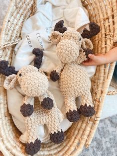 two crocheted stuffed animals sitting in a wicker basket next to a baby's diaper