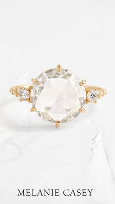 an oval cut white topazte ring with three diamonds on the band and side stones