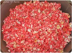 a bowl filled with red popcorn sitting on top of a table