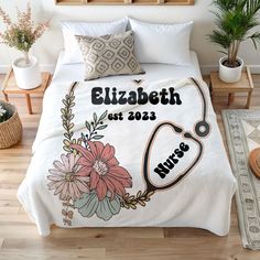 a bed with flowers and a stethoscope on the cover that says elizabeth est 2013