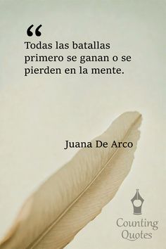 a white feather sitting on top of a table next to a quote from juan de arco