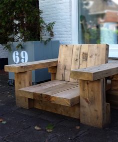 two wooden benches sitting next to each other on a sidewalk near a building with windows