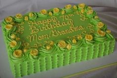 a green birthday cake with yellow flowers on it's edges and the words happy 70th mom grandma