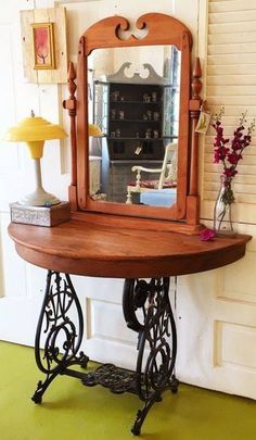 an antique sewing table with a mirror on top