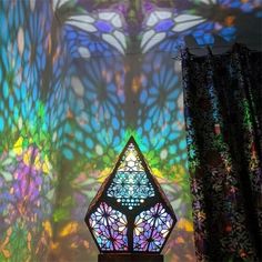 a stained glass window in the middle of a room with curtained walls and curtains