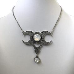 This triple moon necklace is made with antiqued silver plated filigrees and crescent moons, adorned with sparkling WHITE OPAL glass crystals. Centerpiece is 2 1/2" wide and 2 1/2" tall. It is worn with soldered stainless steel cable chain. Necklace is adjustable 15-18" with a lobster clasp and chain extender. If you would like a different length, please send us a message.Matching earrings are listed in our store in a variety of stone colors. If you don't see items with a color you want, feel fre Antique Silver Necklace, Pentagram Necklace, Spiral Necklace, Black Gems, Cable Chain Necklace, Choker Pendant, Triple Moon, Stainless Steel Cable, Suede Cord