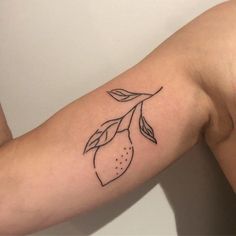 a woman's arm with a tattoo on it that has a lemon on it