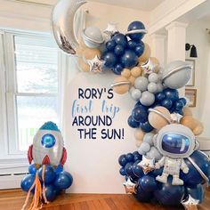 an astronaut balloon arch with balloons attached to it and the words rom's first trip around the sun