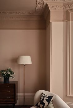 a white chair sitting next to a lamp in a living room