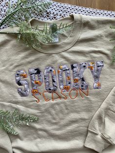 SPOOKY SEASON EMBROIDERED APPAREL ♡ Heavy Blend Crewneck Sweatshirt - Unisex♡ Custom Name and Credentials♡ 50/50 Cotton/Polyester♡ Made in the U.S.♡ Sample photo is "Sand"; Size: S: Spooky Thread: Light Purple; Season Thread: Copper ------------------------------------- CLOTHING SIZE CHARTS WE RECOMMEND SIZING UP FOR A LOOSER FIT. These crewnecks are on the smaller end compared to other brands. We cannot replace a size after receiving your order. ------------------------------------- Please mess Fall Long Sleeve T-shirt With Machine Embroidery, Long Sleeve T-shirt With Machine Embroidery For Fall, Cute Embroidered Text Tops For Fall, Cute Tops With Embroidered Text For Fall, Cute Embroidered Sweatshirt For Fall, Halloween Embroidery Sweatshirt, Embroidered Name Sweatshirt, Embroidered Sweatshirt Diy, Embroidered Apparel