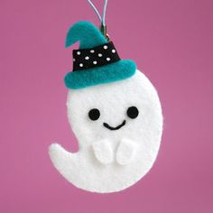 a white ornament with a blue hat on it's head hanging from a string