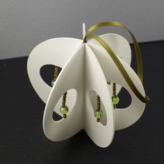 an ornament shaped like a flower with green beads on it's petals