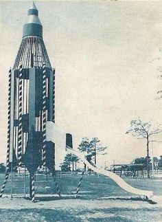 an old black and white photo of a building with a slide in it's center