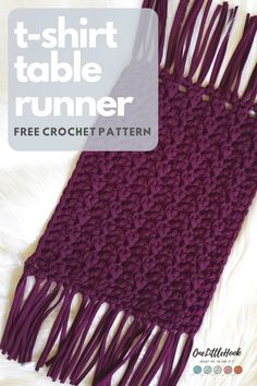 the t - shirt table runner is knitted in purple yarn and has fringes on it