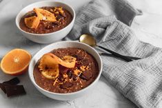 two bowls filled with chocolate pudding and sliced oranges