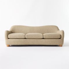 a beige couch sitting on top of a white floor