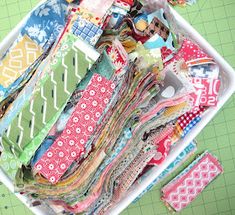 a white tray filled with lots of different types of fabric