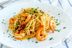 pasta with shrimp and parsley on a white plate