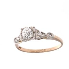 an antique diamond ring with three diamonds on the side and two sides, set in yellow gold