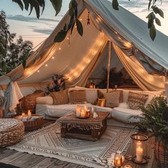 a large tent with candles on the floor and lights hanging from it's roof