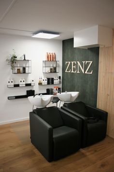 two black chairs sitting in front of a wall with shelves on each side and one chair facing the other