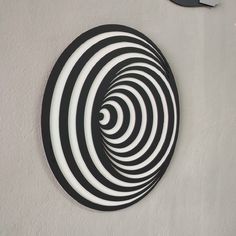 a black and white circular design is on the wall next to a pair of scissors