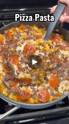 a pan filled with pizza sitting on top of a stove next to a person holding a spat