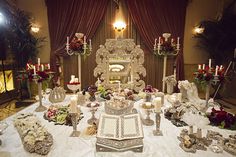 an elaborate table with candles and flowers on it