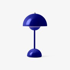 a blue table lamp sitting on top of a white floor