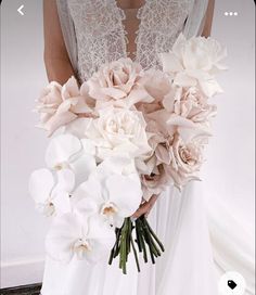 a bride holding a bouquet of white and pink flowers