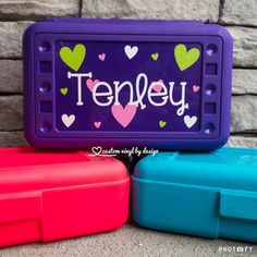 three plastic lunch boxes with the word tenley written on one side and hearts painted on the other